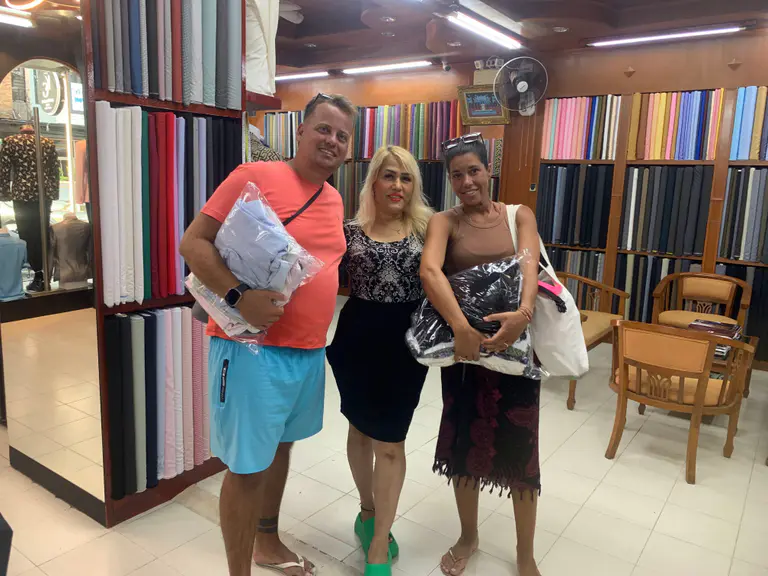 Happy clients collecting custom clothing inside Kenny & Gita Tailor in Kata, Phuket