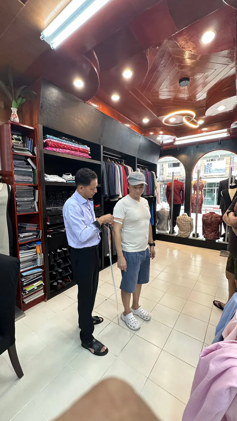 Tailor taking body measurements for bespoke clothing at Kenny & Gita Tailor in Phuket