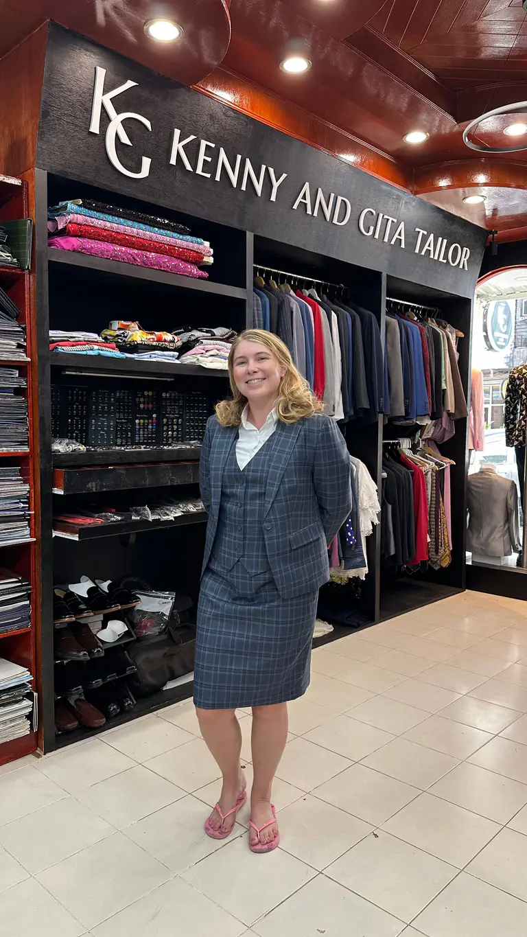 Client wearing a tailored gray skirt suit at Kenny & Gita Tailor in Phuket