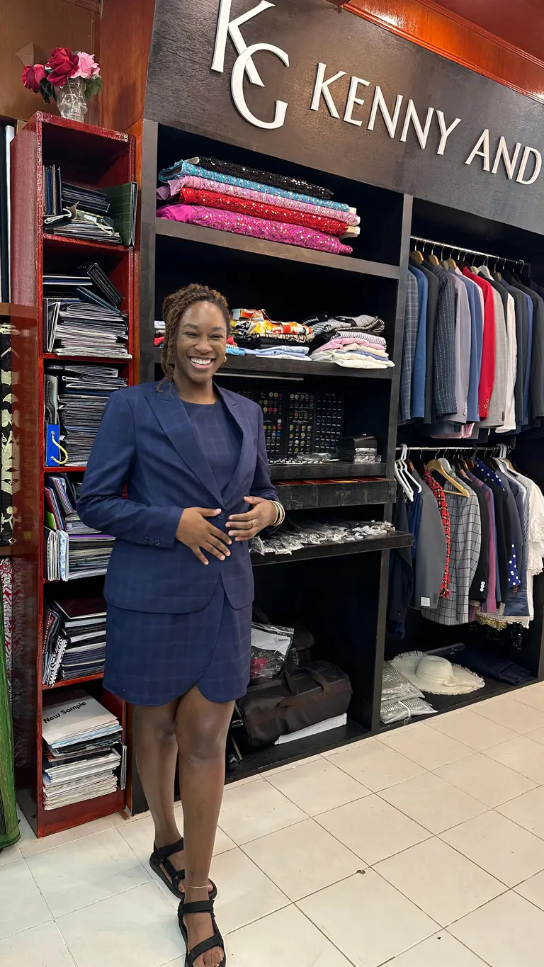 Client smiling in a fitted navy skirt suit at Kenny & Gita Tailor in Kata, Phuket