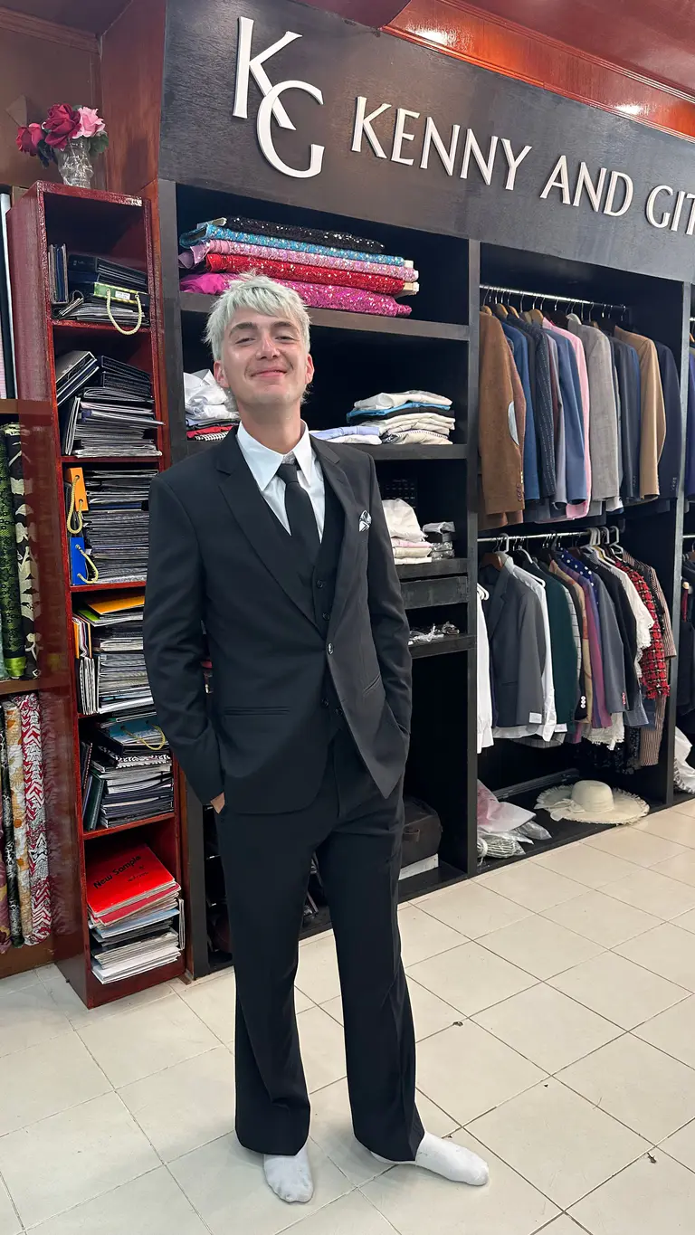 Young client wearing a finished black suit at Kenny & Gita Tailor in Kata, Phuket